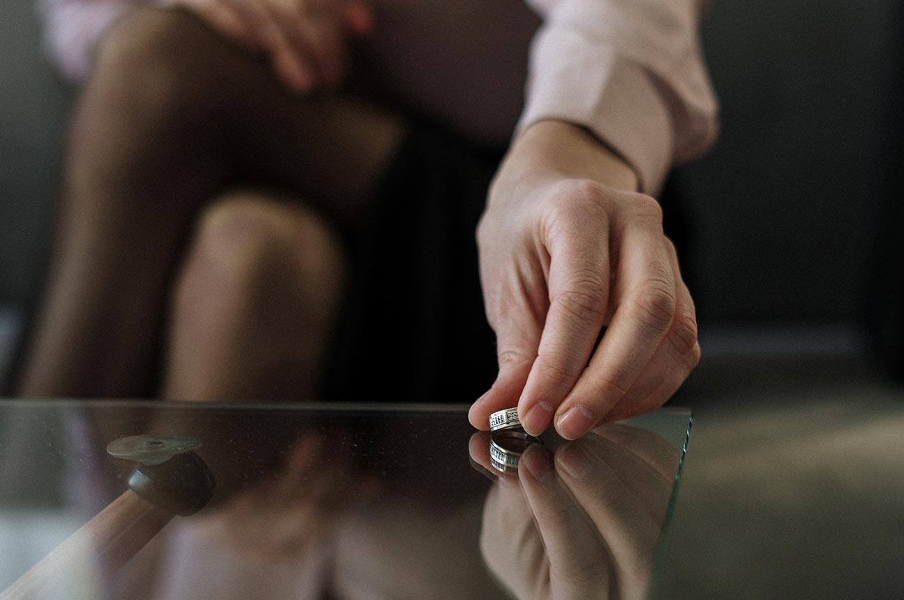 woman's hand placing wedding band on table